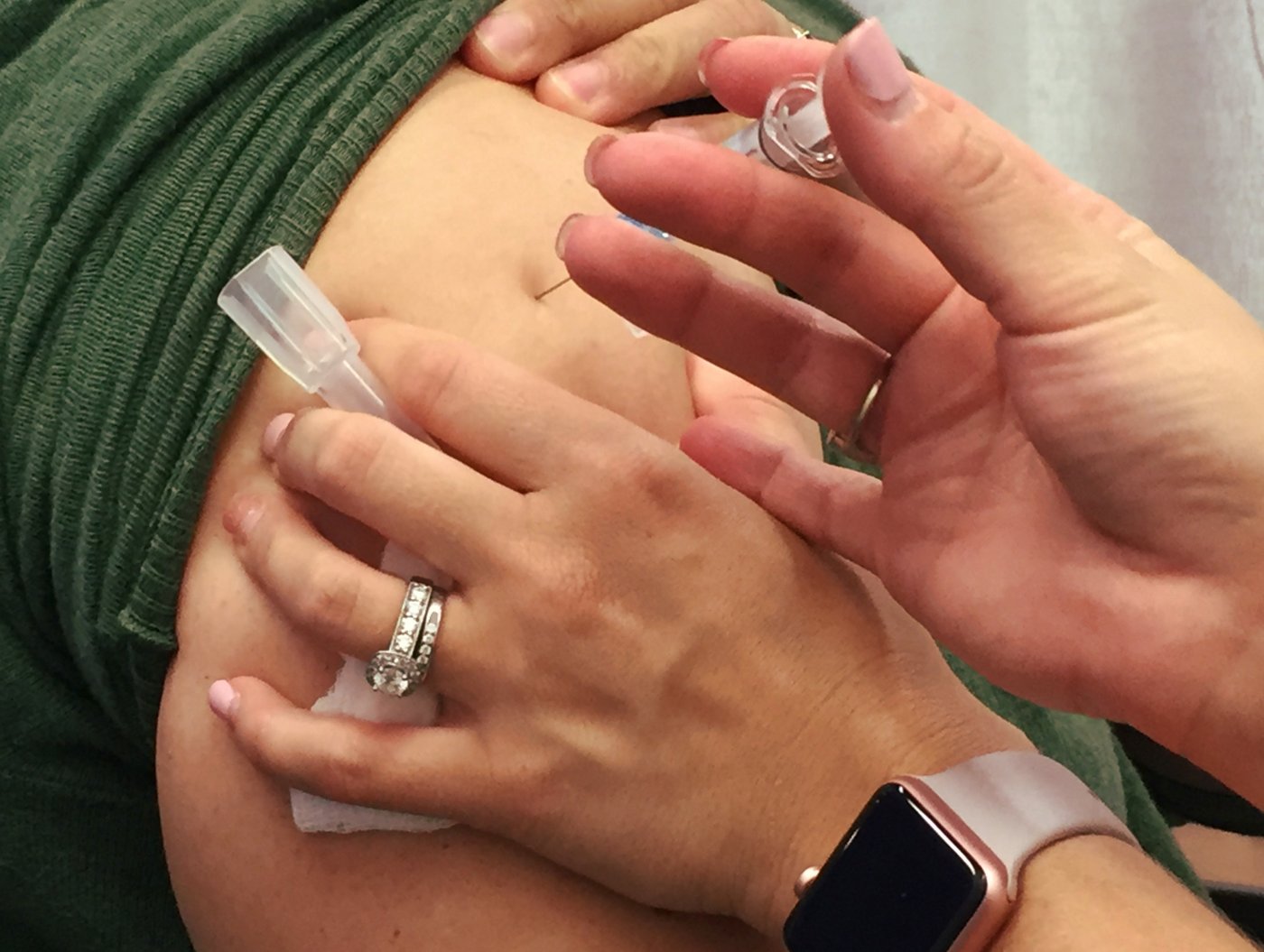 En kvinna får en spruta med säsongsvaccin mot influensa i överarmen