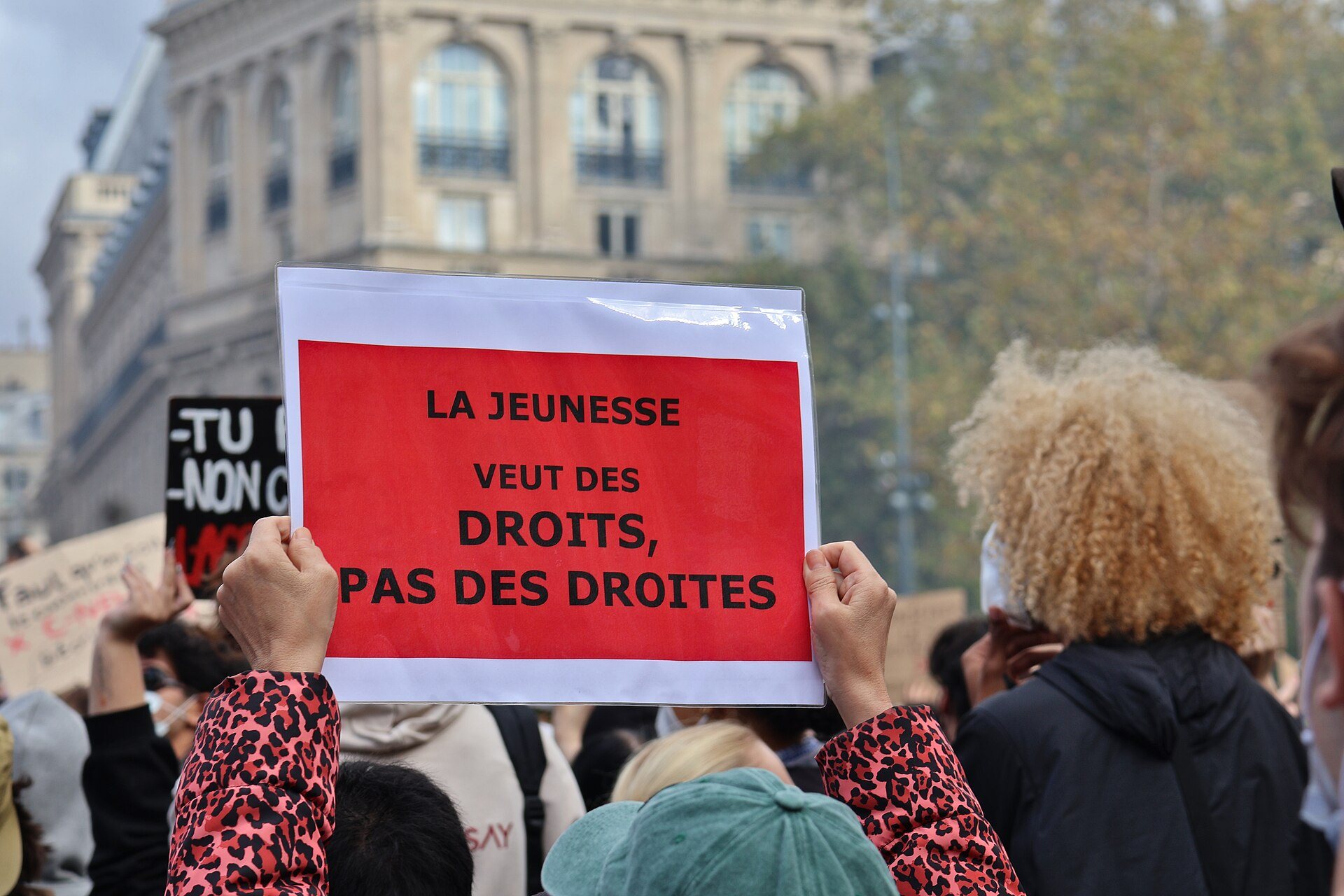 Unga demonstranter i Paris håller upp en röd skylt med texten ”La jeunesse veut des droits, pas des droites” under protestdagen den 17 oktober 2026